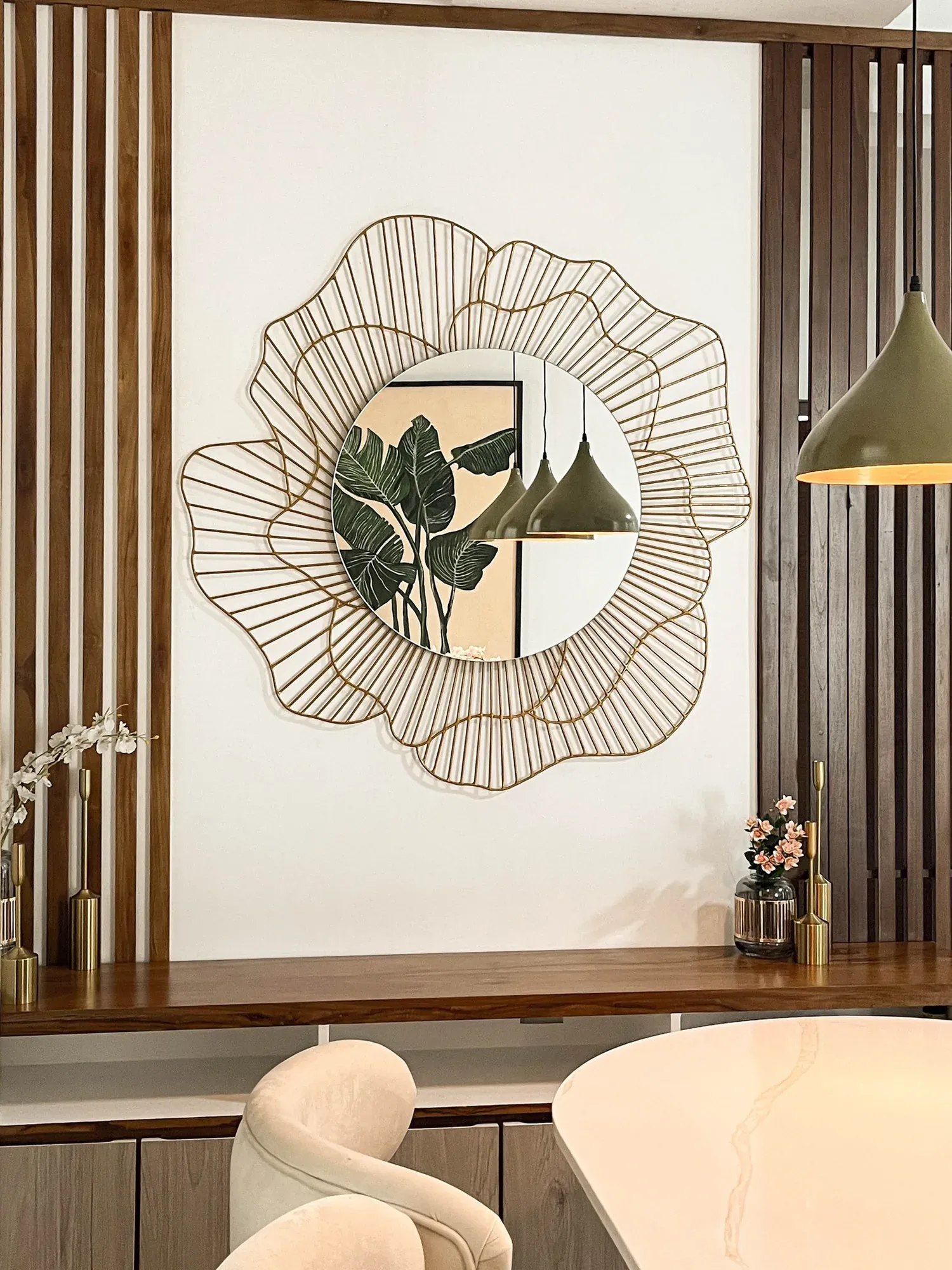 Sculptural mirror framed by vertical timber slats above a console