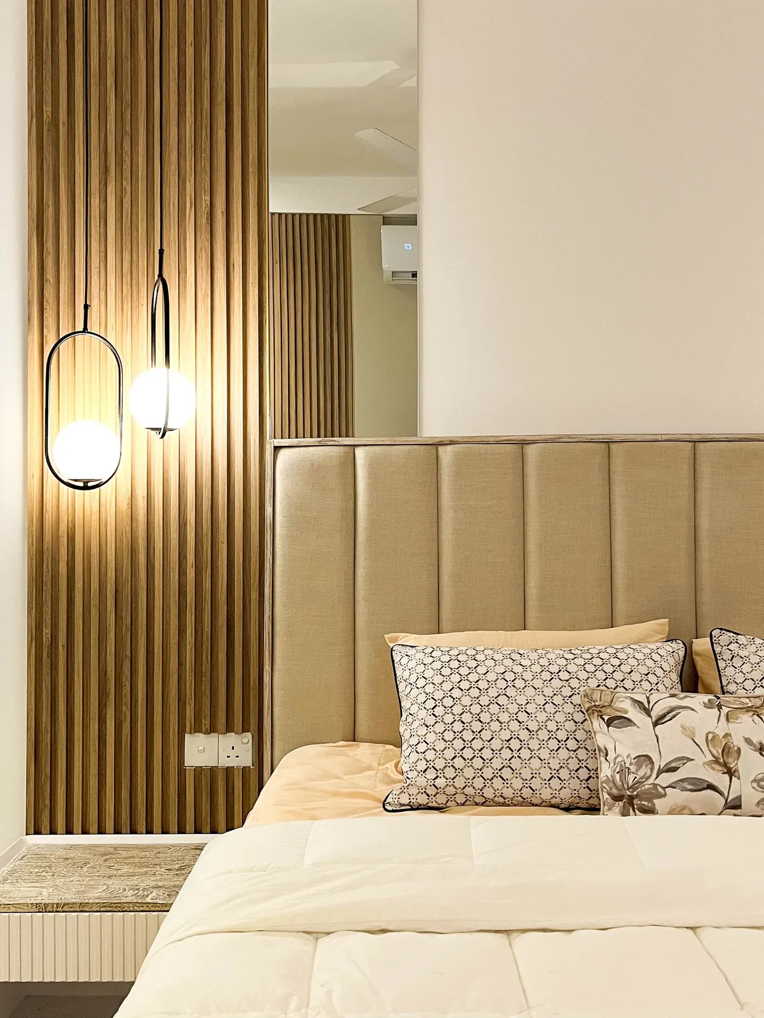 Close-up of the channel-tufted headboard, slats and oval pendant light